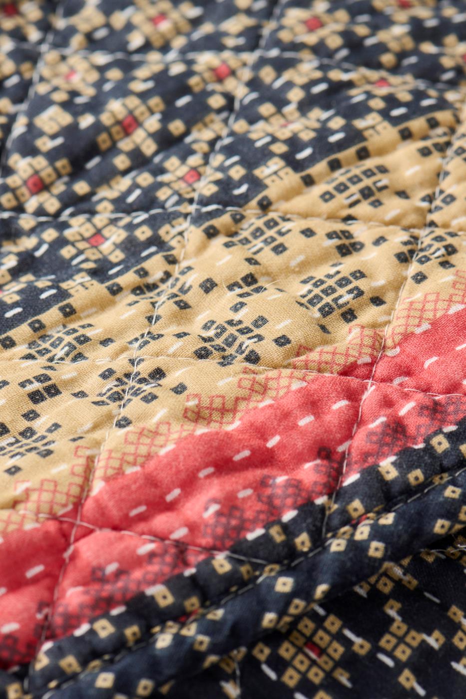 Quilt dark blue w/light pink and natural coloured pattern, borders lengthwise